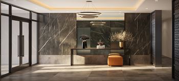 A modern office lobby with a marble wall and a circular light fixture.